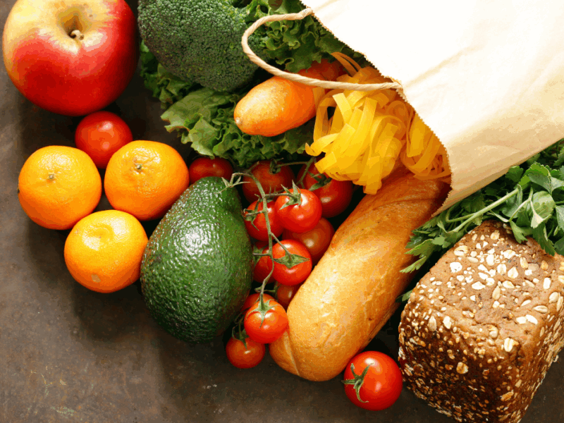 Photo is of a shopping bag with fresh food coming out of it.